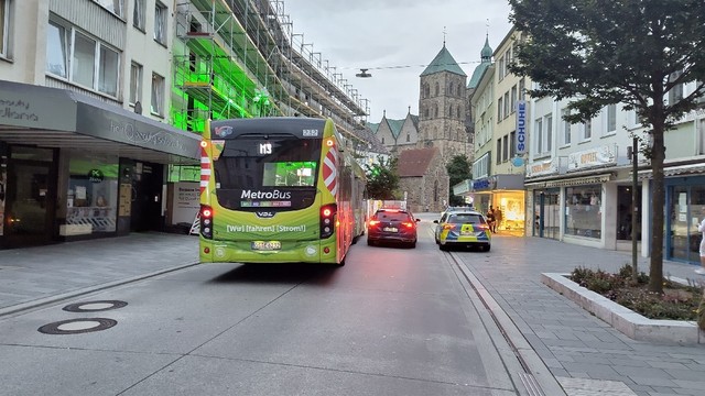 Johannisstraße in Osnabrück Blickrichtung Johanneskirche. Zwei Polizeiautos (1x zivil und 1x offiziell)  blockieren die Straße, sodass ein Linienbus nicht vorbeikommt.