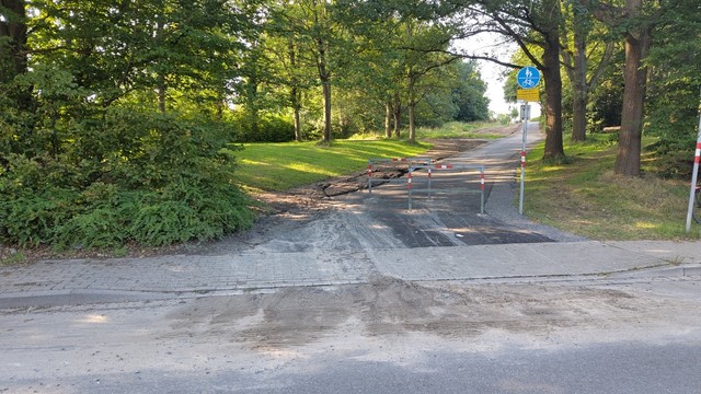 Kurt Schumacher Damm Blickrichtung hoch zur neu asphaltierten Bredowstraße. Auf dem Radschutzstreifen liegt ein Erdesandgemisch. 