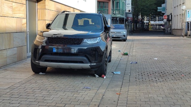 SUV in der Osnabrücker Innenstadt im Bereich Am Kamp. Unter und neben dem SUV liegt Müll.