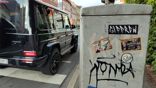 Sticker von extinction rebellion auf einen Verteilerkasten an der Martinistraße in Osnabrück 

Gelbe Umrandung 

Schwarzer SUV fährt auf der Martinistraße stadtauswärts.